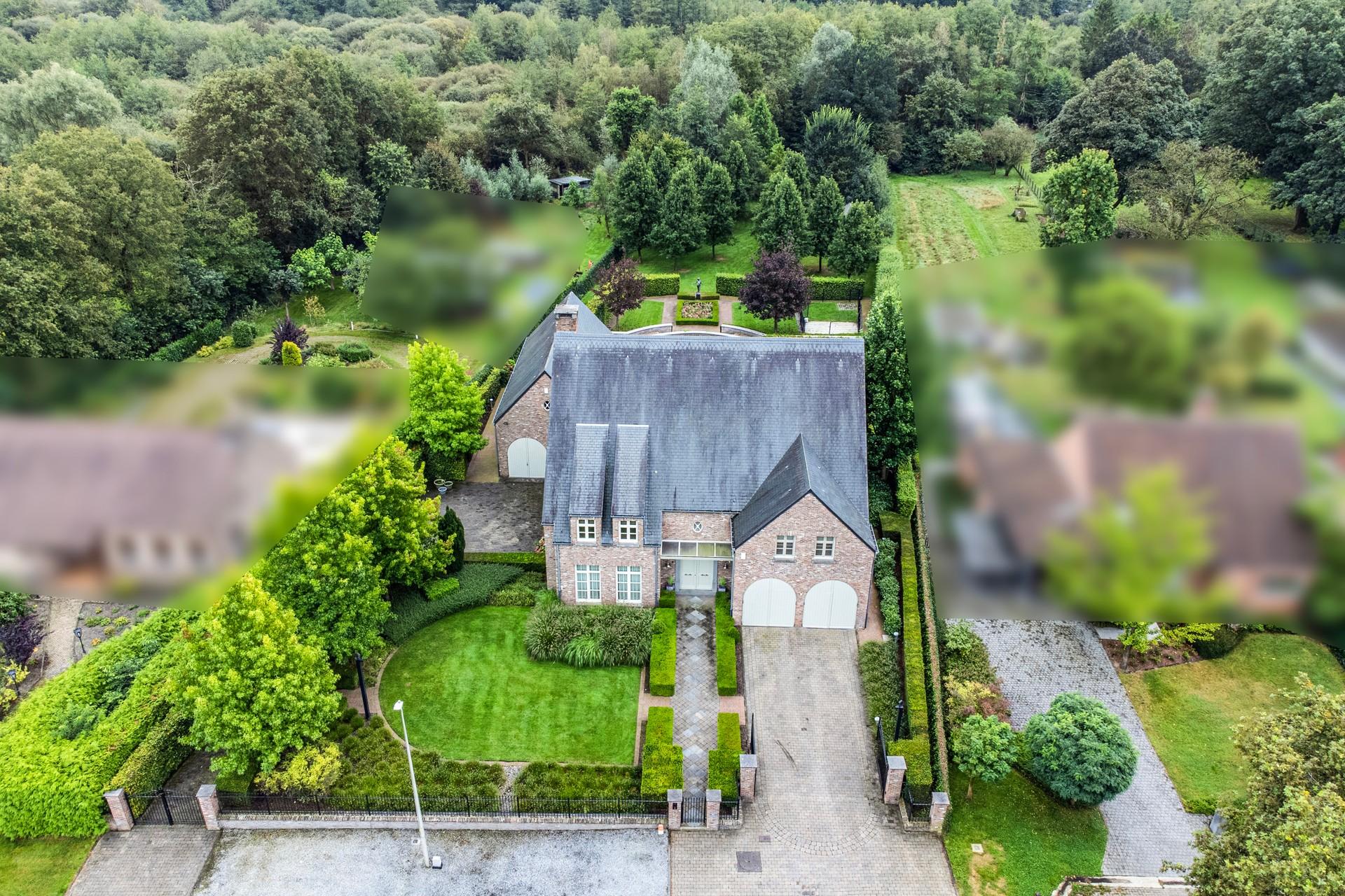 Landhuis met binnenzwembad en mutifunctioneel bijgebouw in residentiële omgeving.